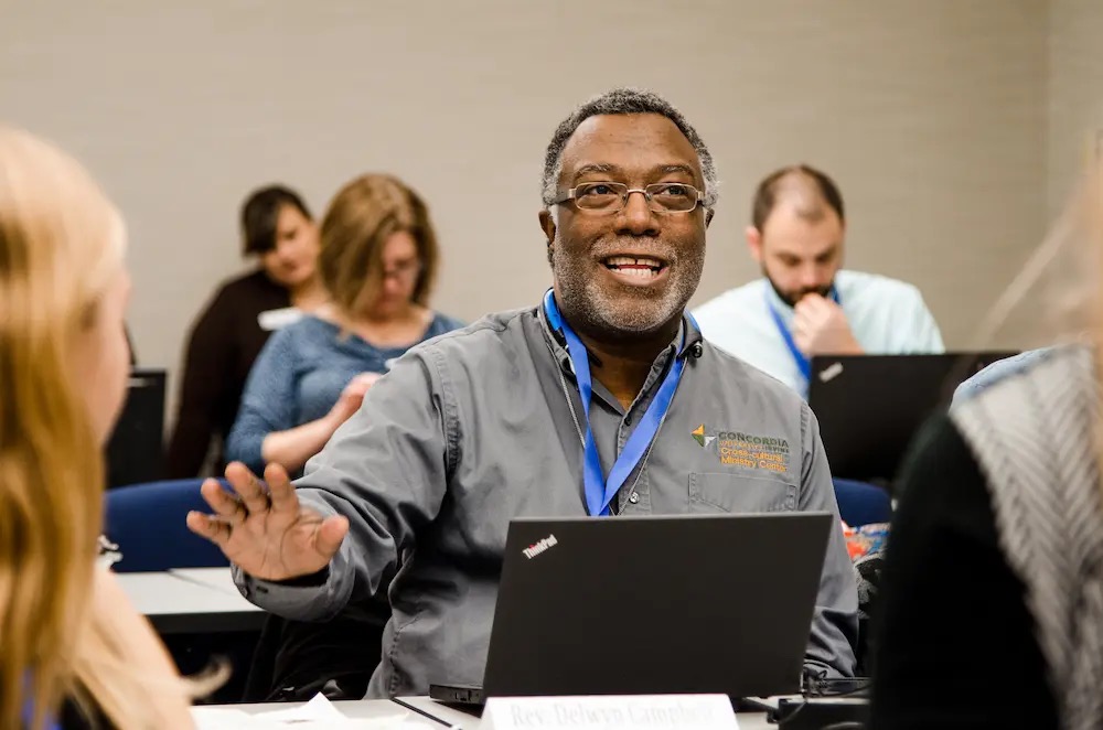 A man sitting at a table with a laptop