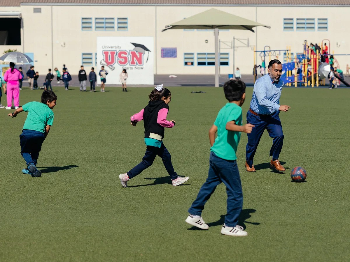 A man and kids playing football