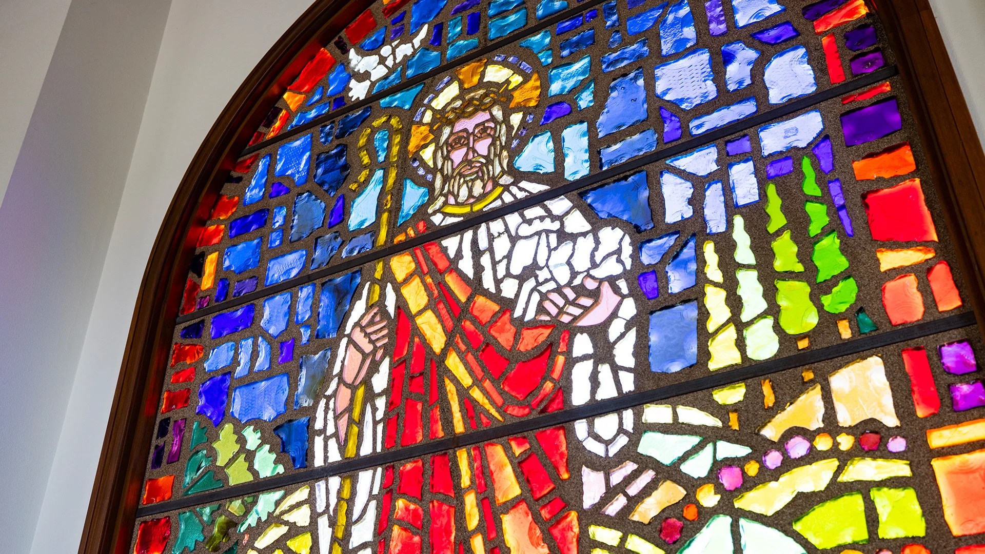 A stained glass window with a religious figure