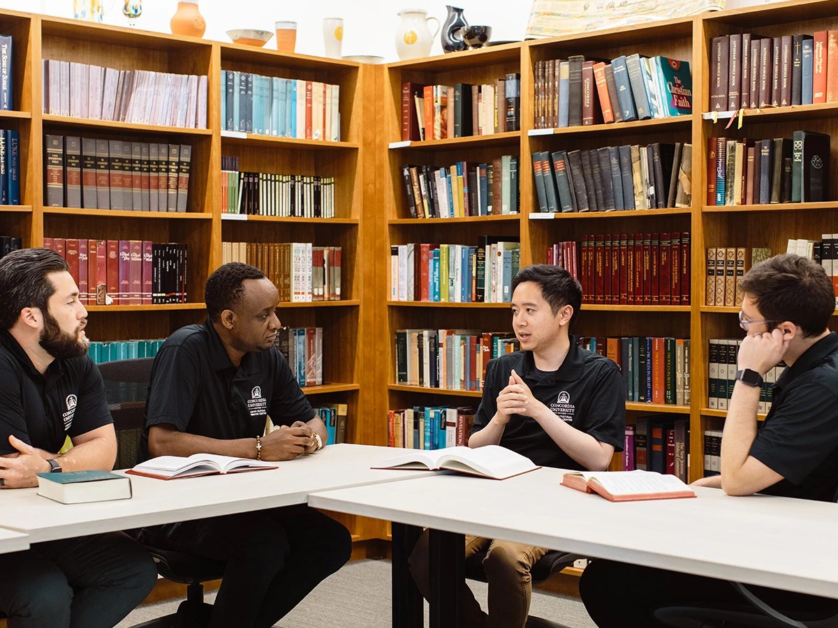 A group of people sitting at a table in a library
