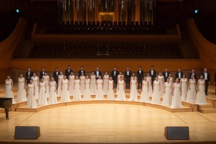 A group of people in white dresses on a stage