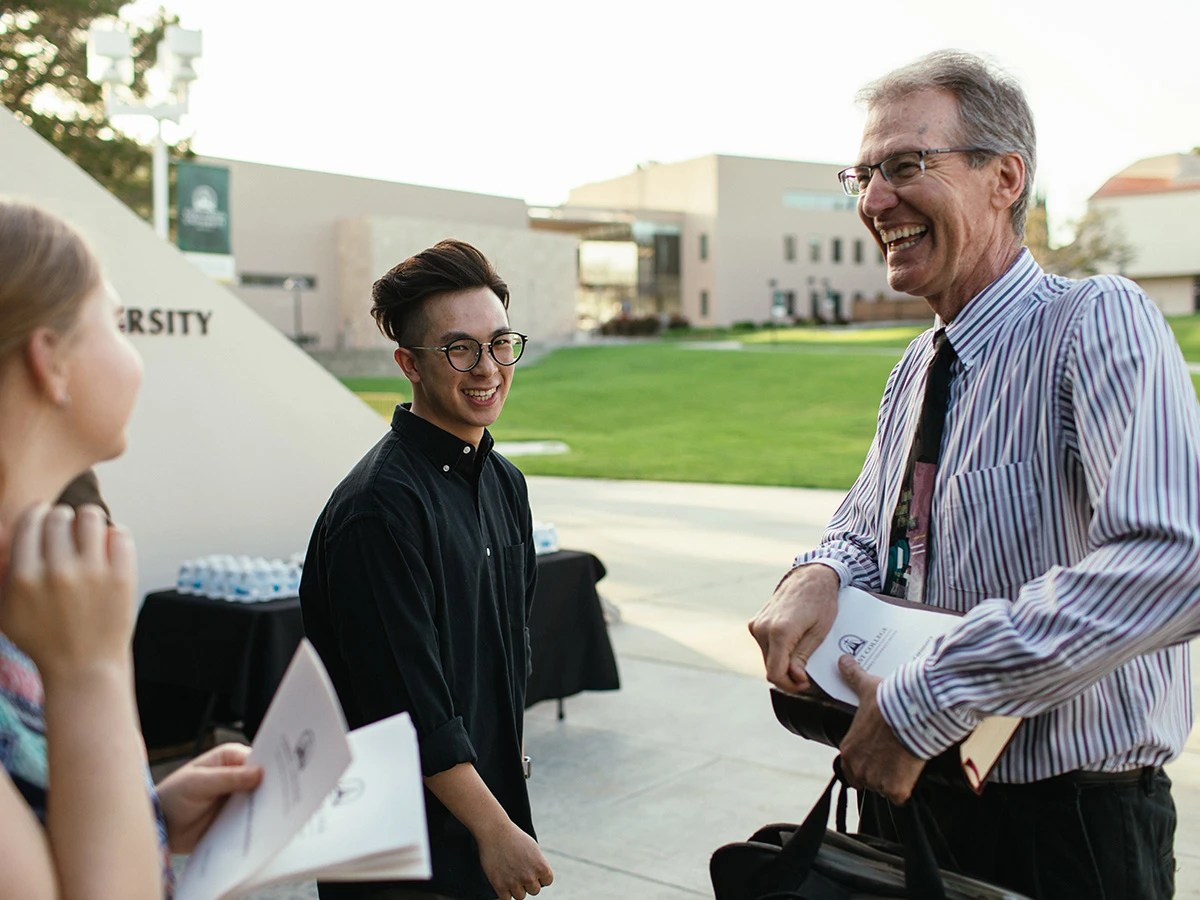 Group of students talking with a professor