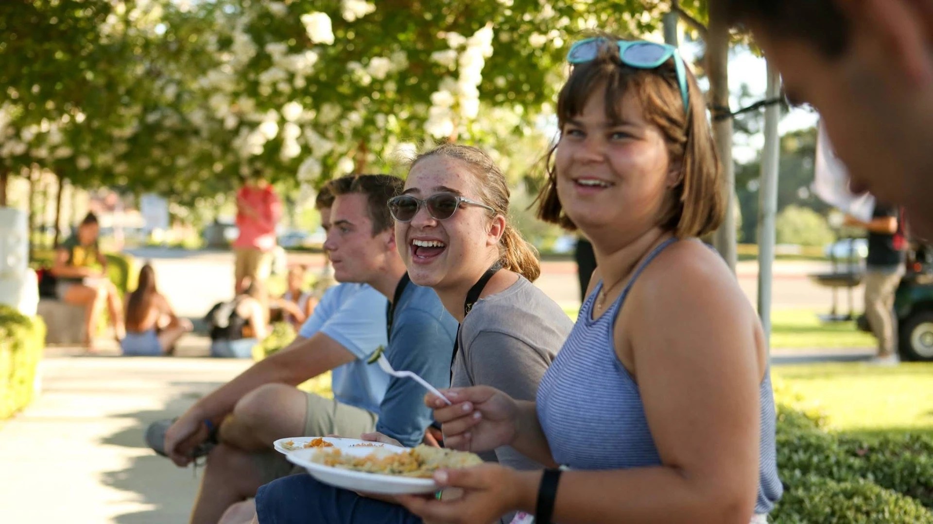 A group of people sitting outside eating