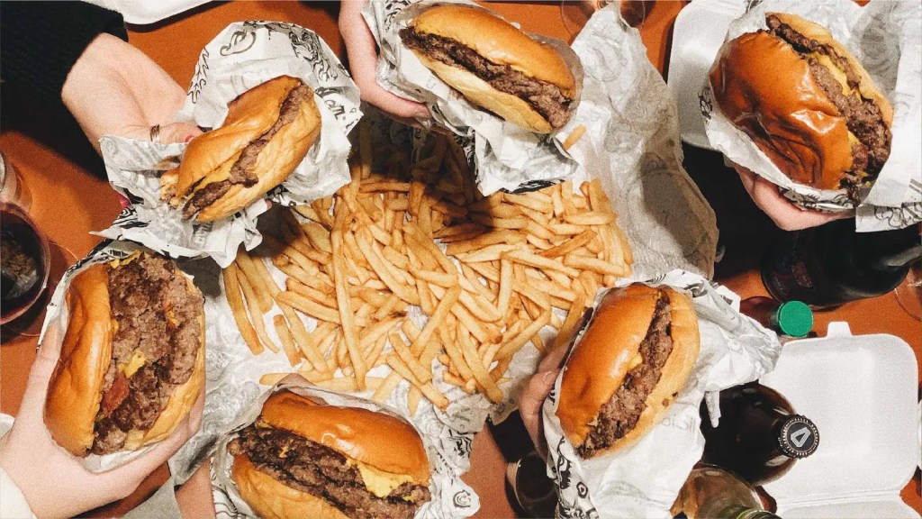 A group of burgers and fries on a table