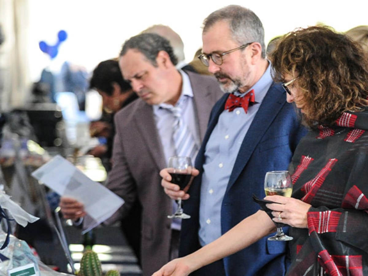 A group of people holding wine glasses