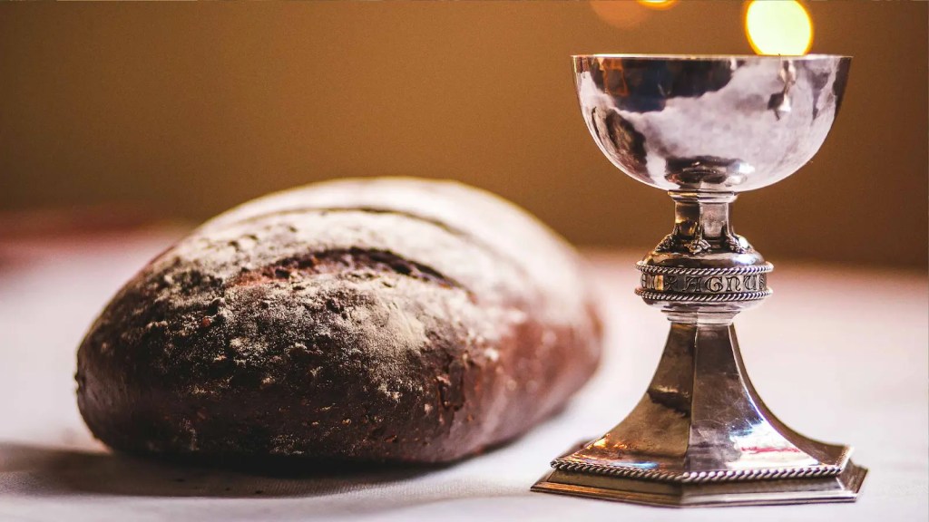 A chalice and bread on a table