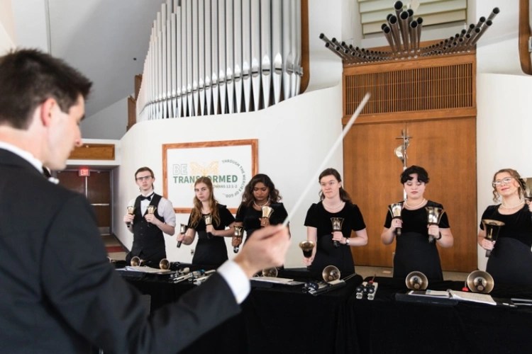 A group of people holding bells