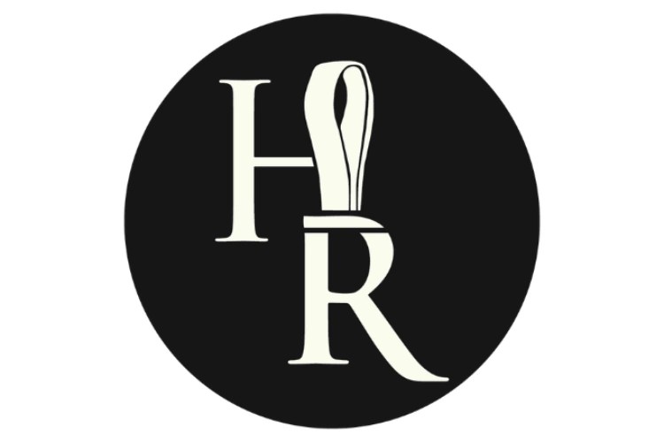 A black circle with white letters and a ribbon