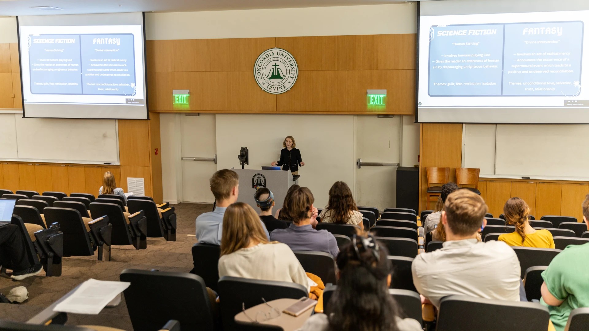 A woman standing in front of a group of people in a lecture hall
