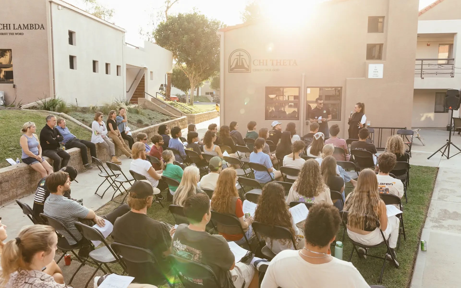 A group of people sitting in chairs outside a building