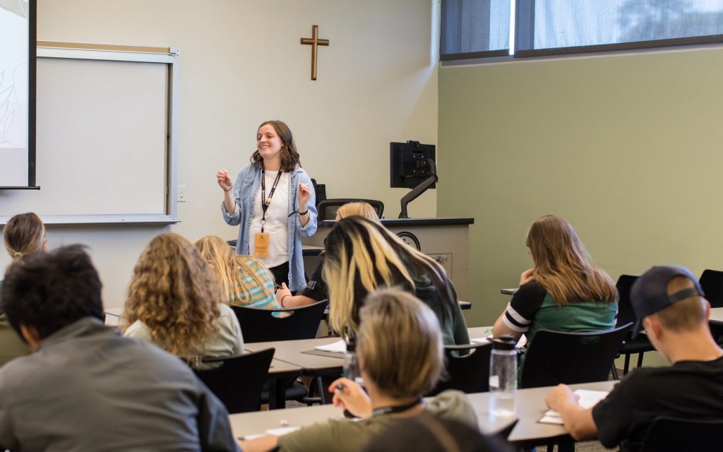 A woman standing in front of a classroom