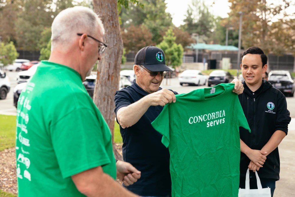 A group of men holding a green shirt