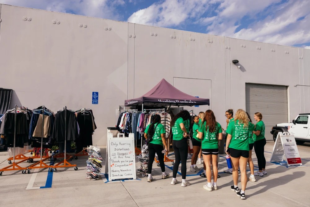 A group of women in green shirts outside a store