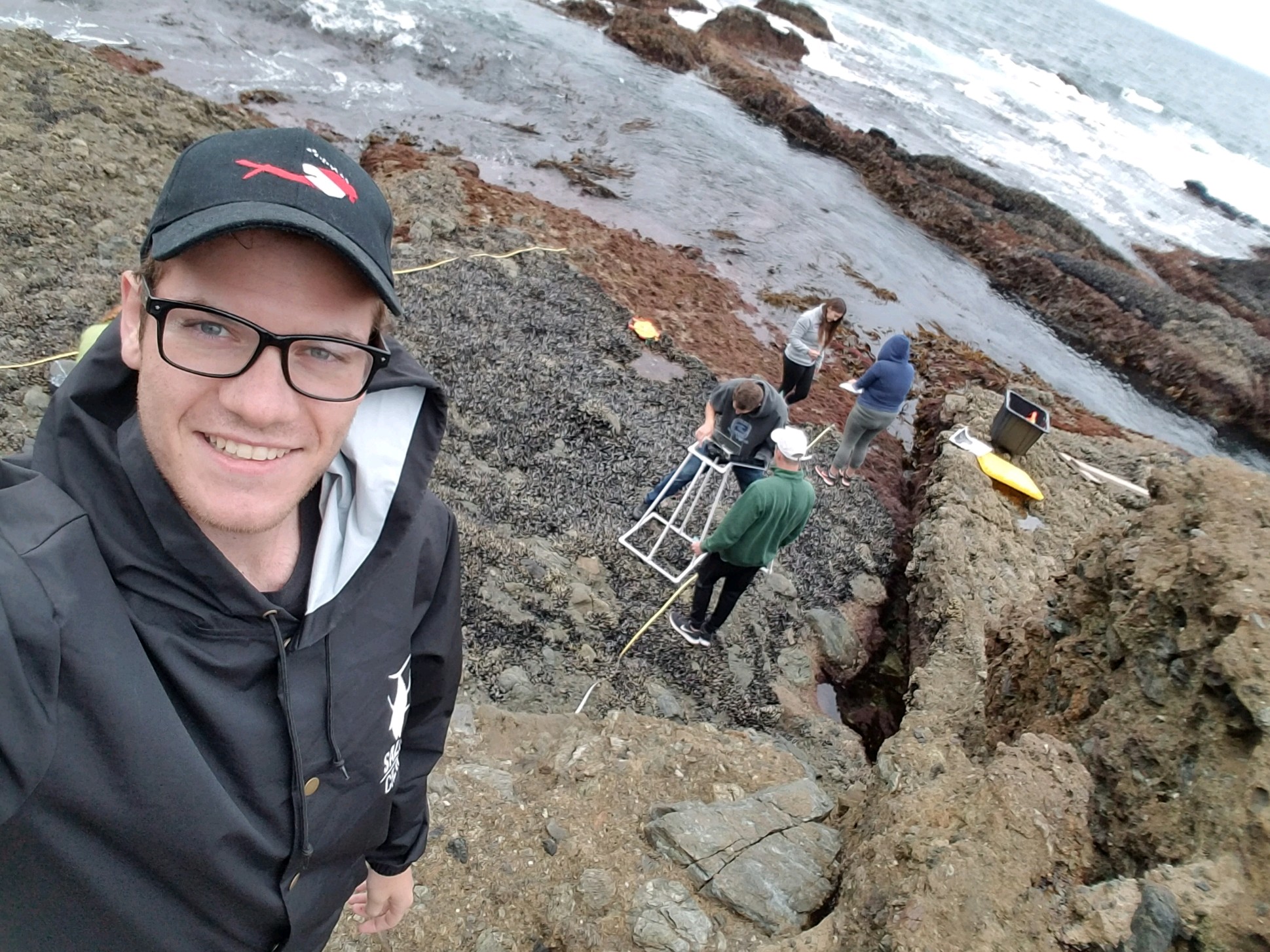 A man taking a selfie on a rocky beach