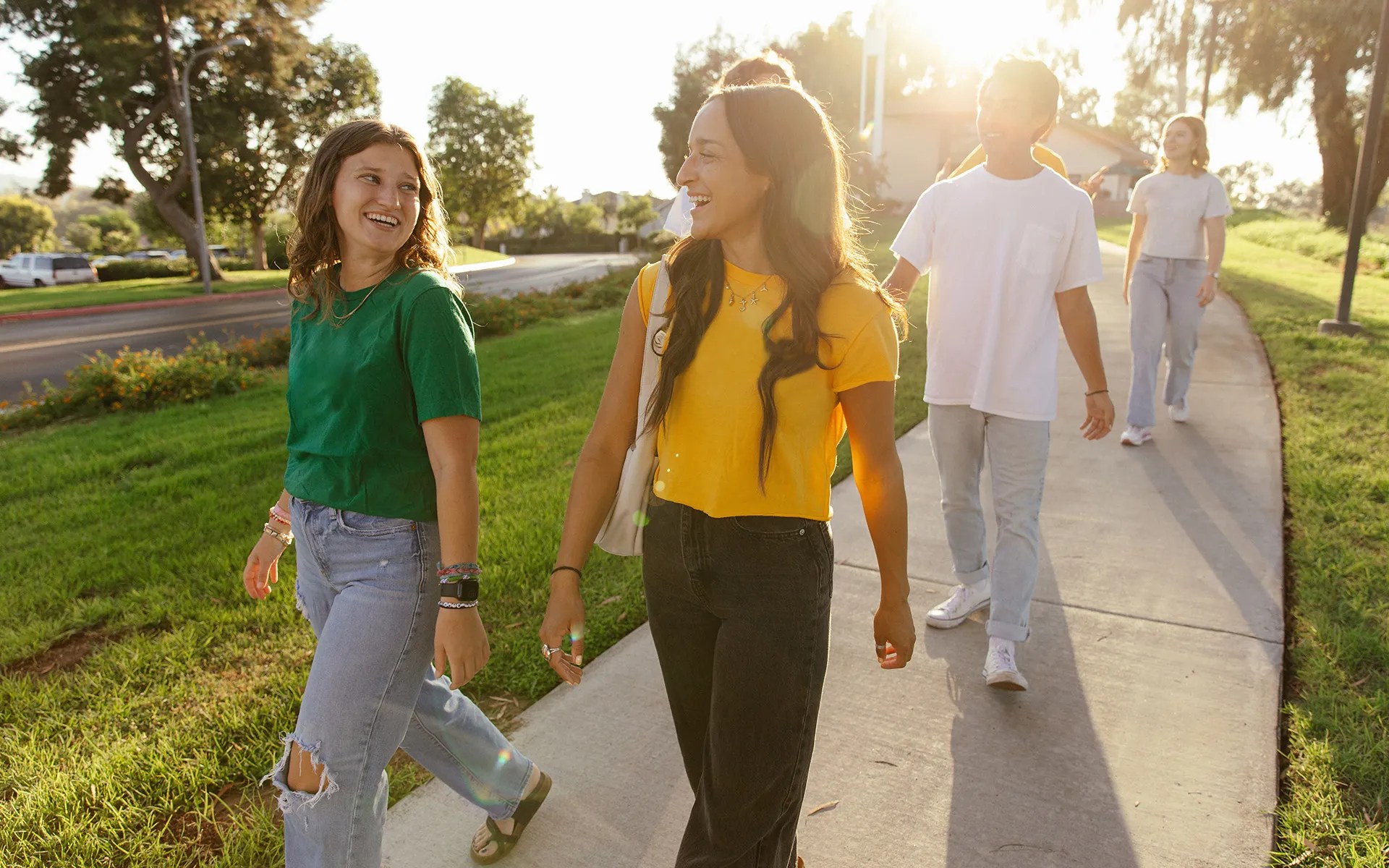 A group of people walking on a sidewalk