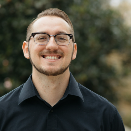 A man wearing glasses smiling