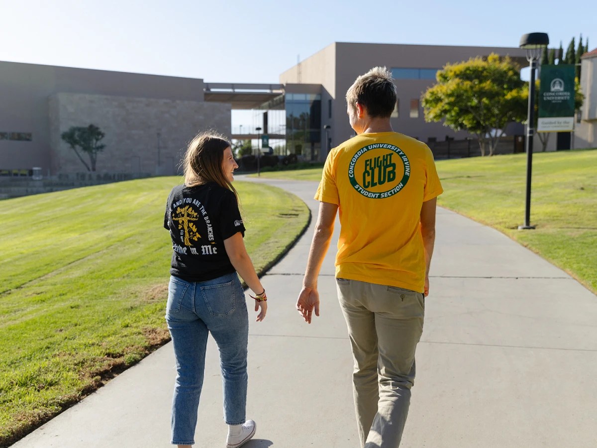 A man and woman walking on a sidewalk