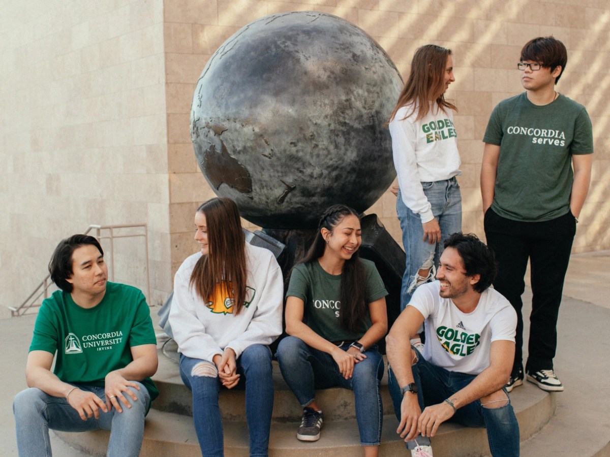 A group of people sitting on a stone ledge