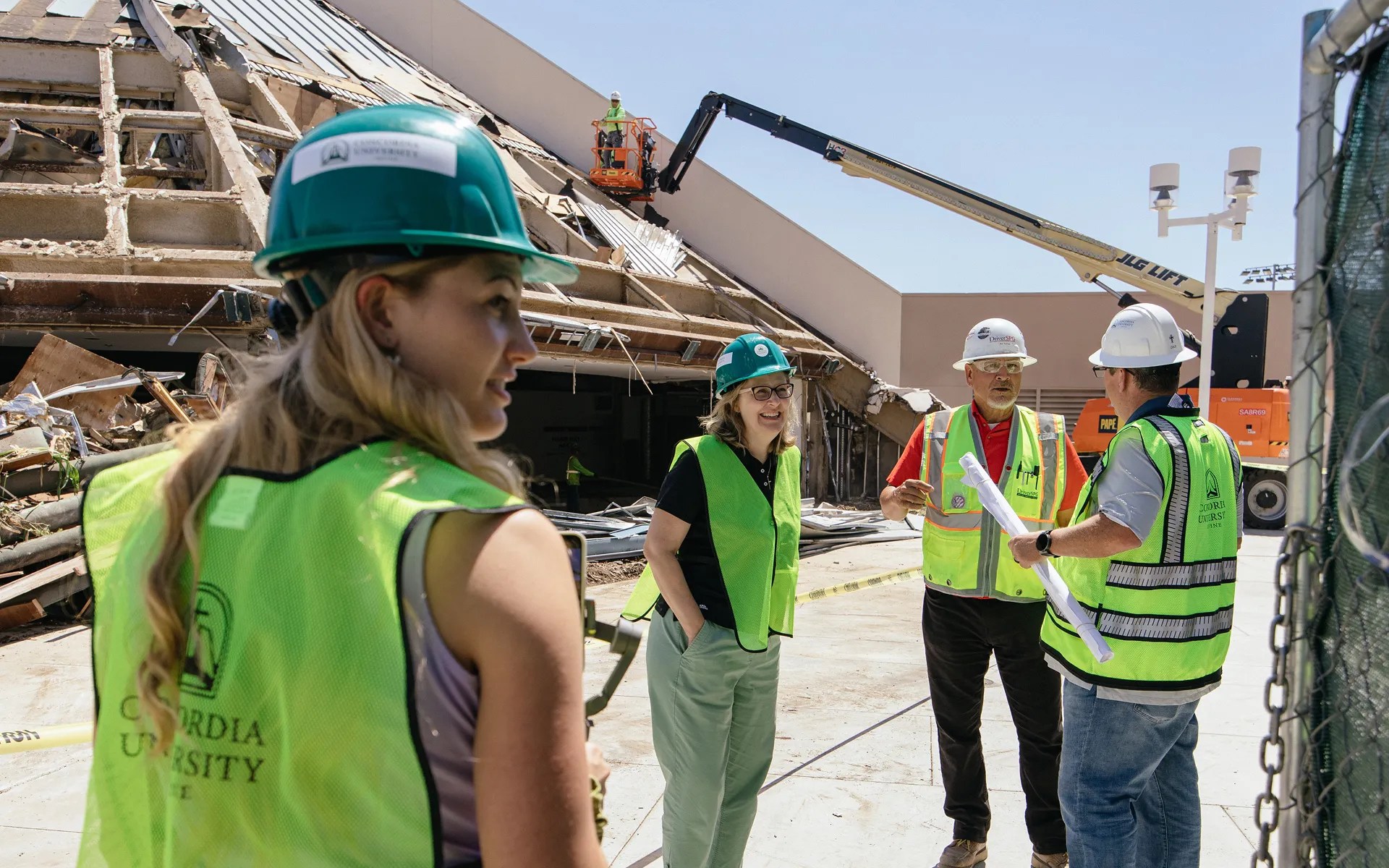 A group of people wearing hard hats and vests