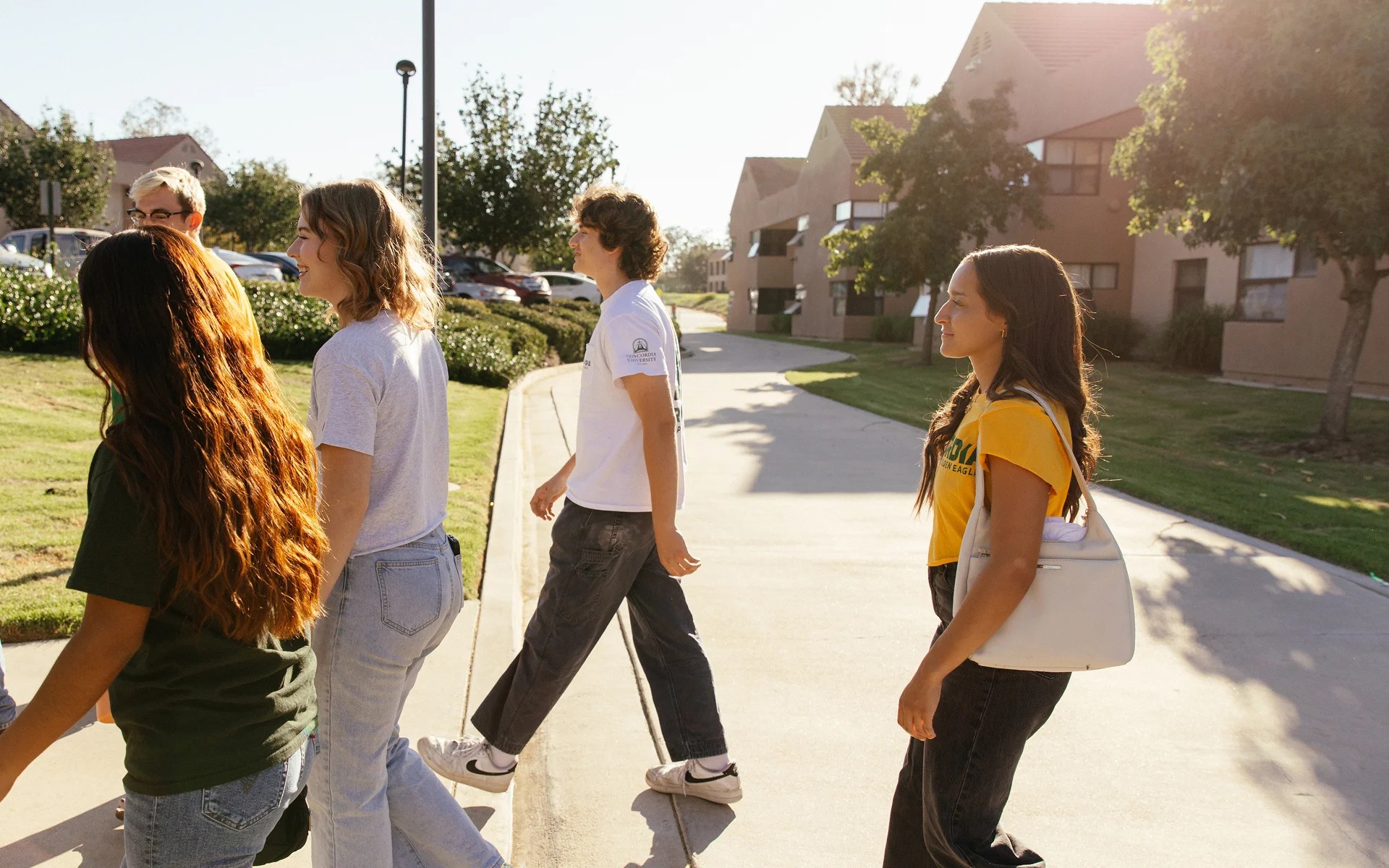 A group of people walking on a sidewalk