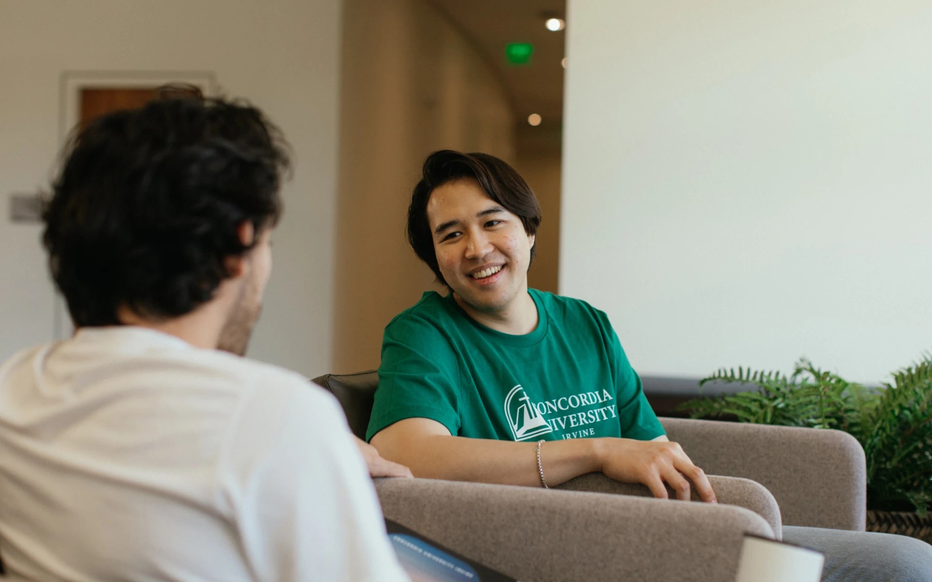 A man in a green shirt sitting in a chair