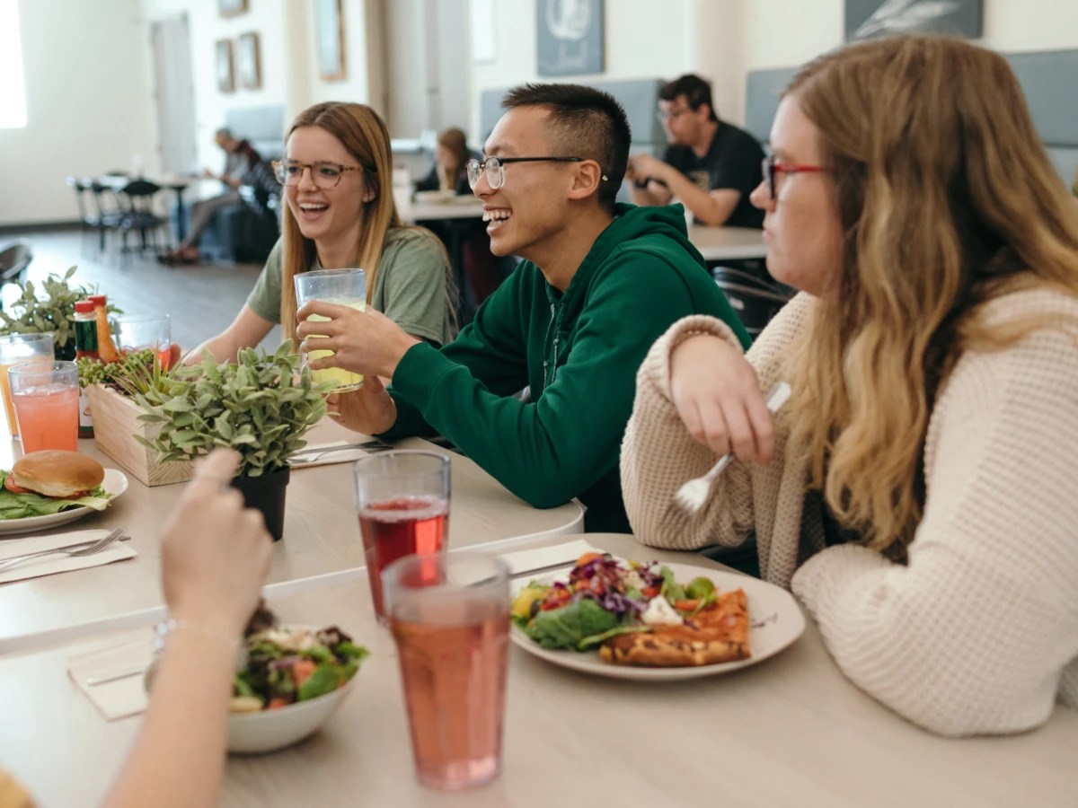 A group of people sitting at a table eating food