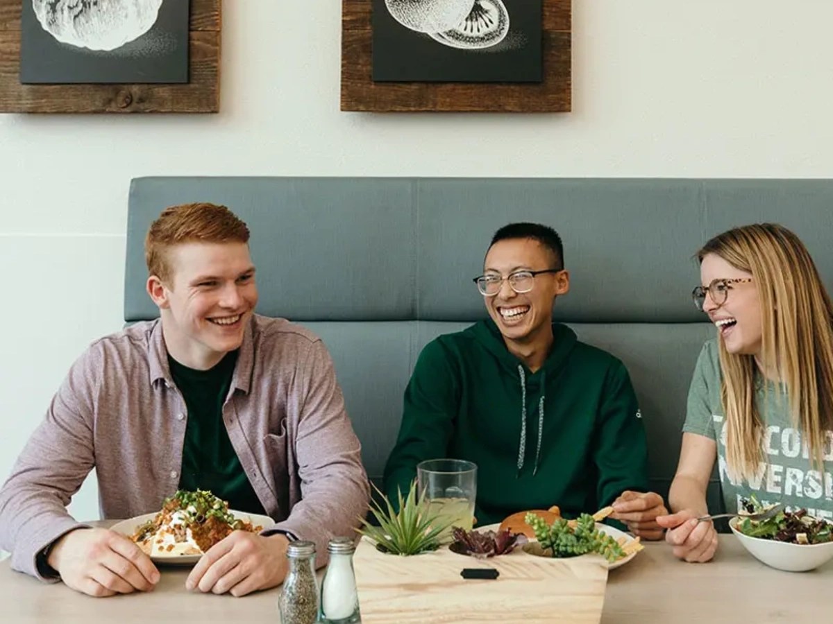 A group of people sitting at a table smiling