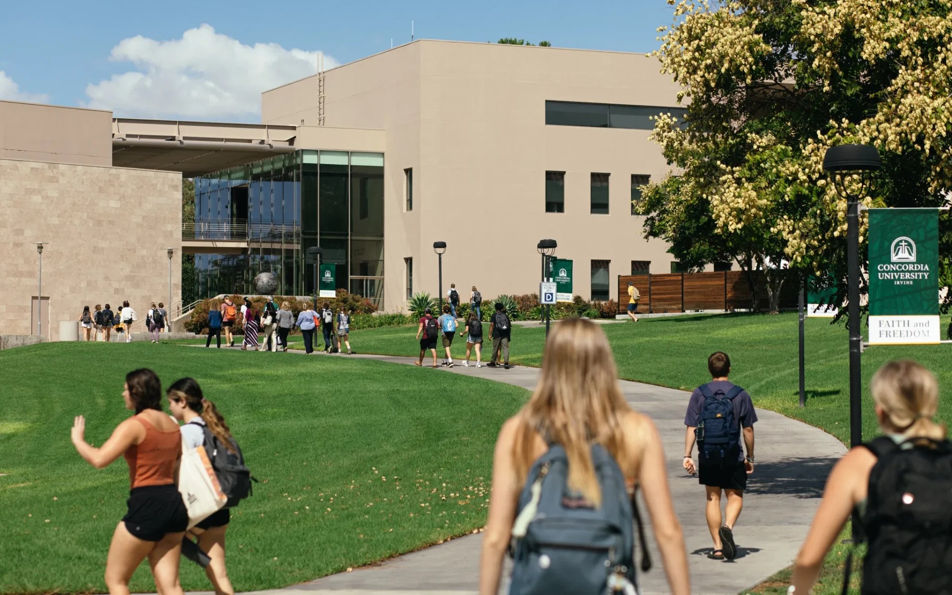 A group of people walking on a path outside a building