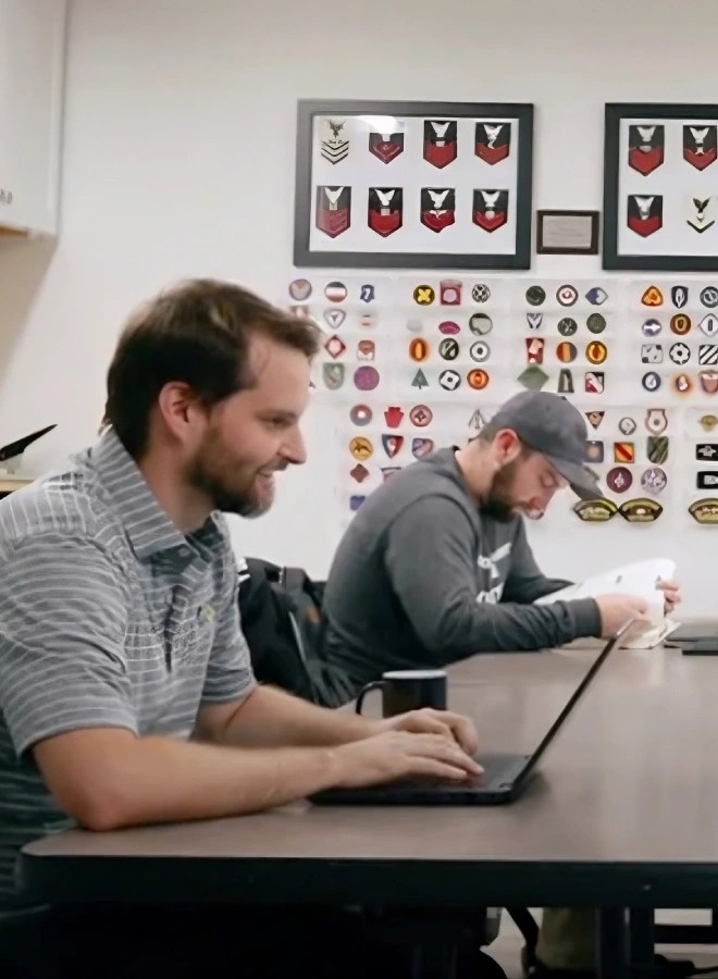 A man sitting at a table with a laptop