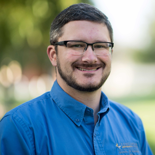 A man wearing glasses and a blue shirt