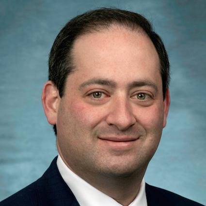 A man in a suit smiling