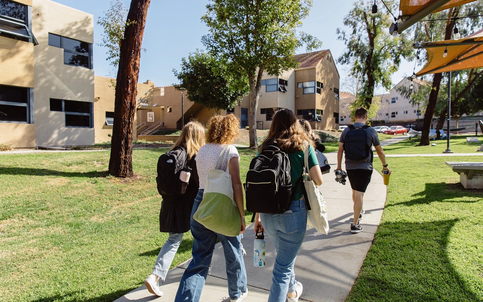A group of people walking on a sidewalk