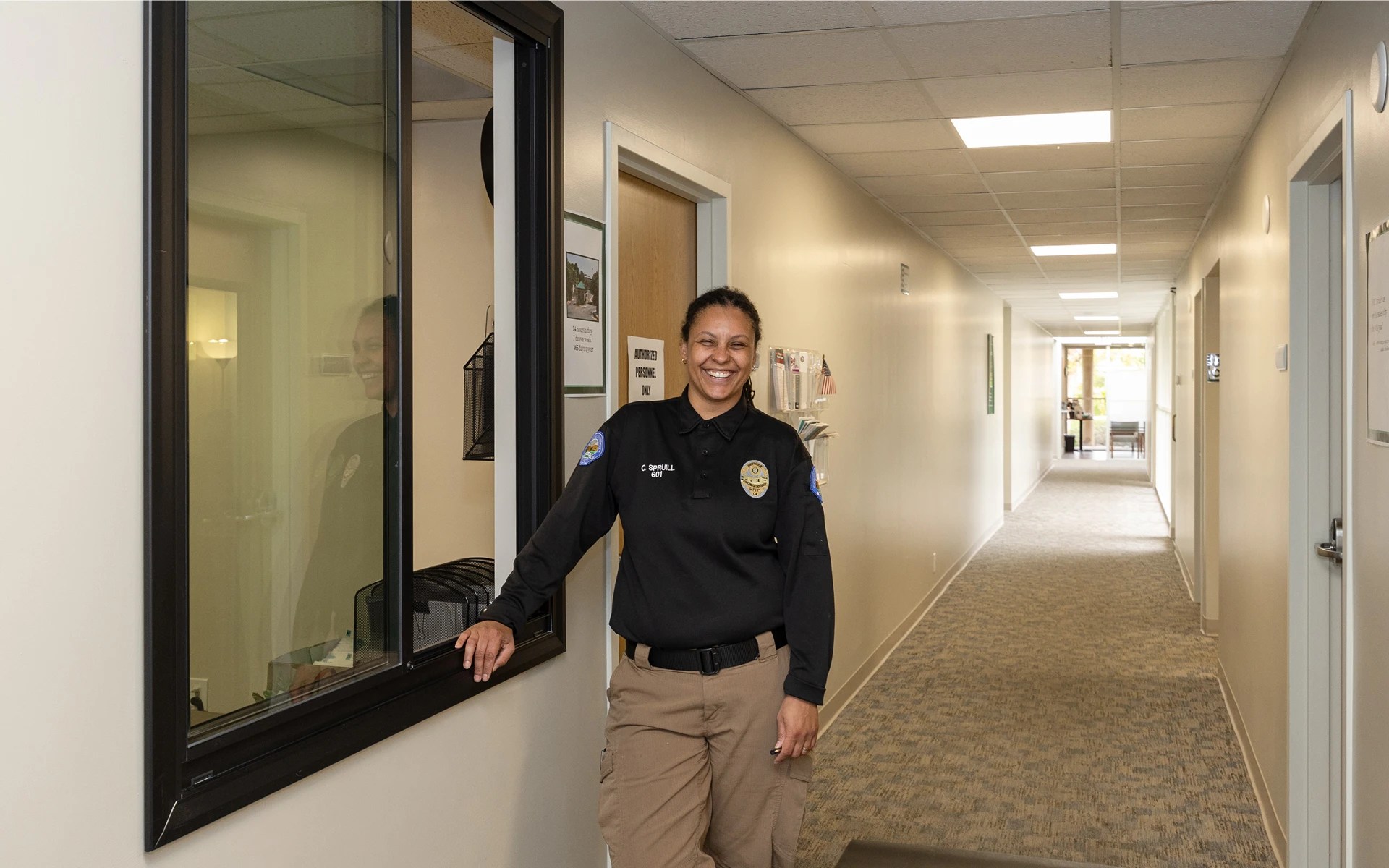 A woman in a police uniform standing in a hallway