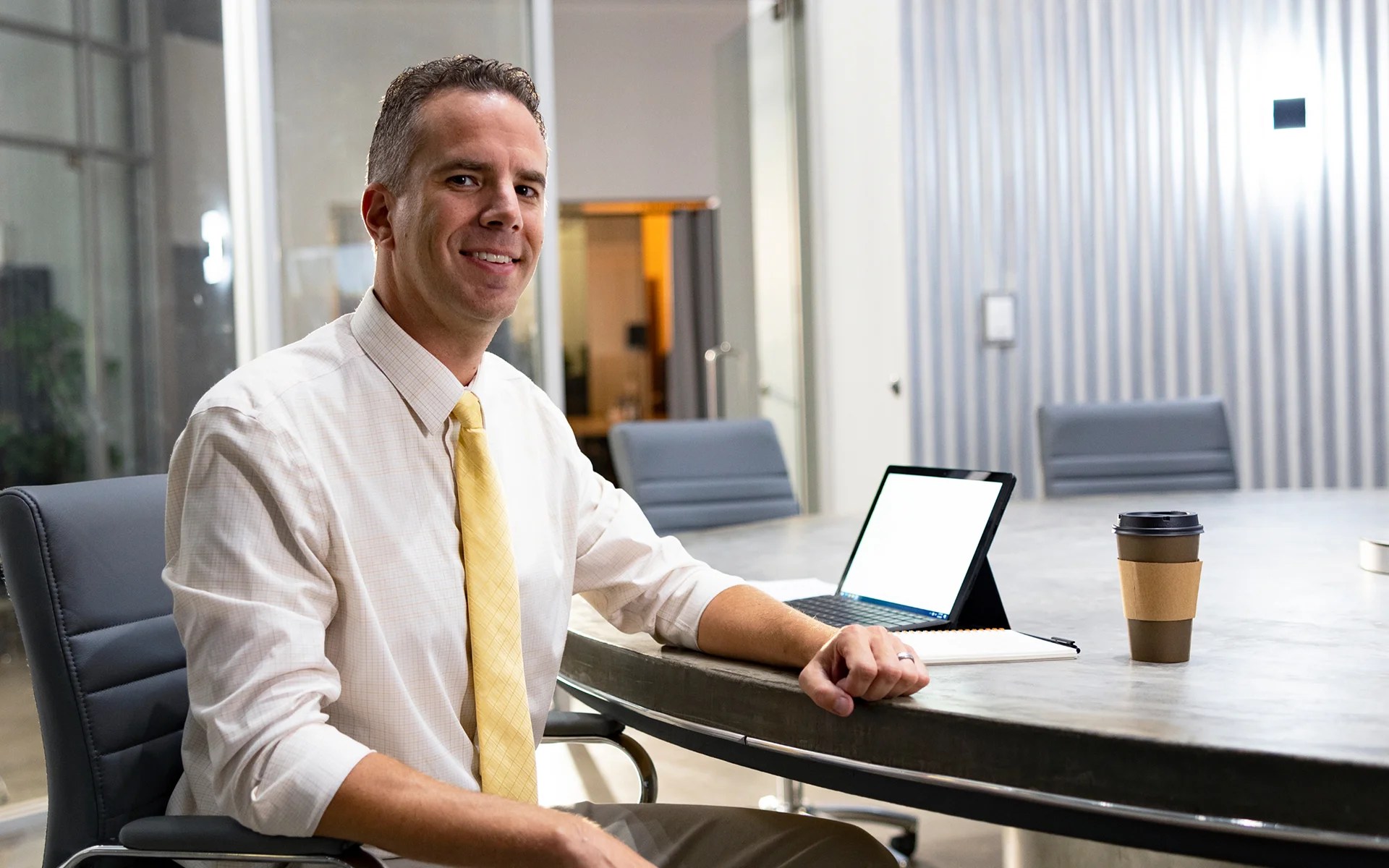 A man sitting at a table with a laptop