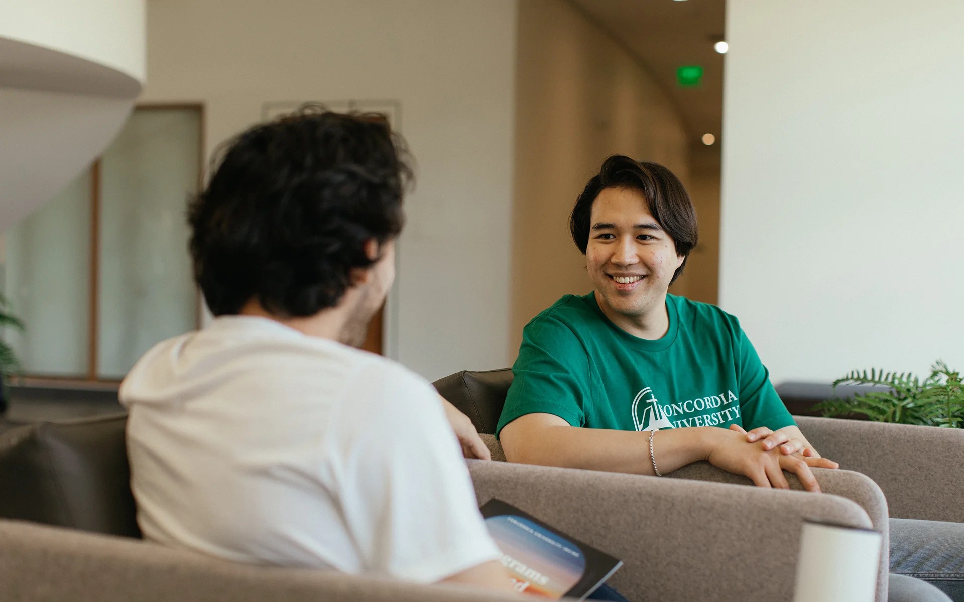 A man in a green shirt talking to another man