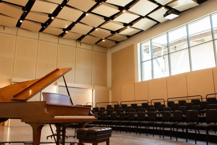 A piano in a room with chairs