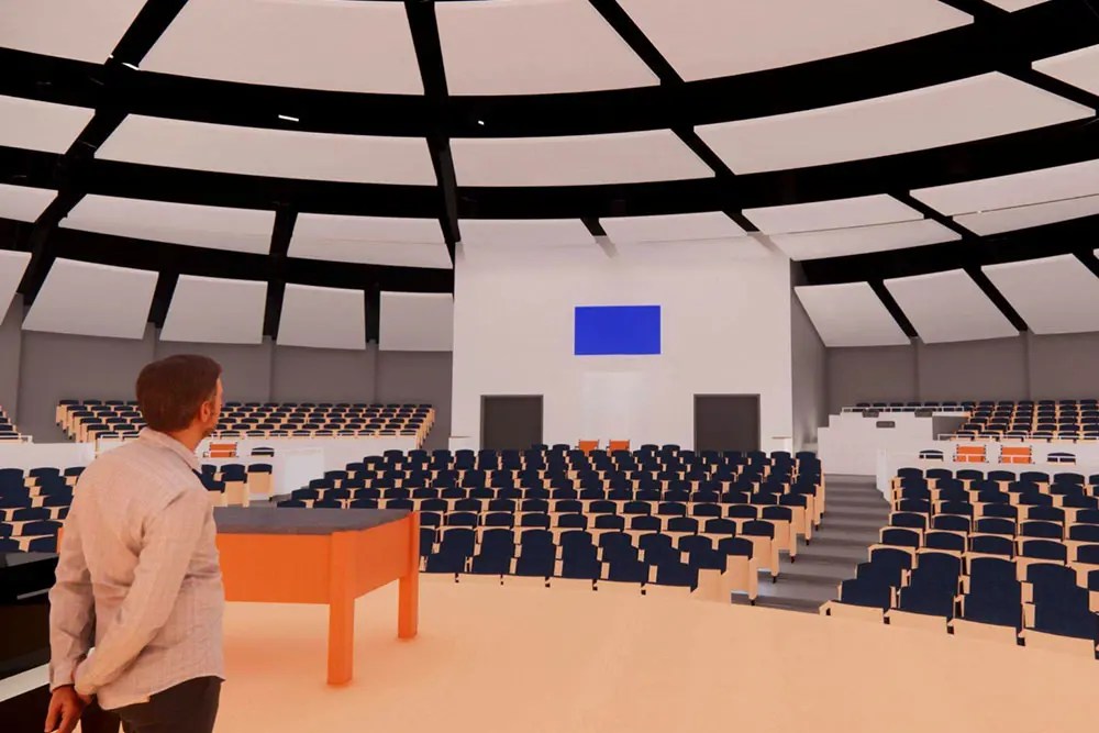 A man standing in a large auditorium