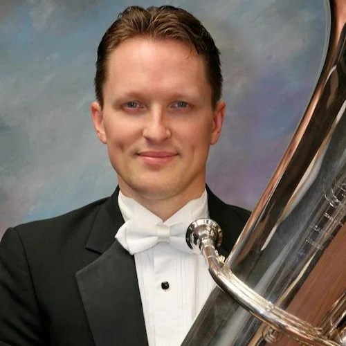 A man in a tuxedo holding a tuba