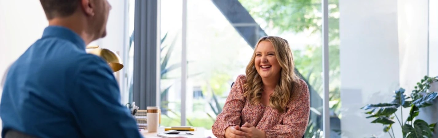 A woman laughing at a table