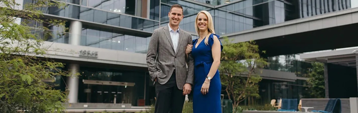 A man and woman standing in front of a building