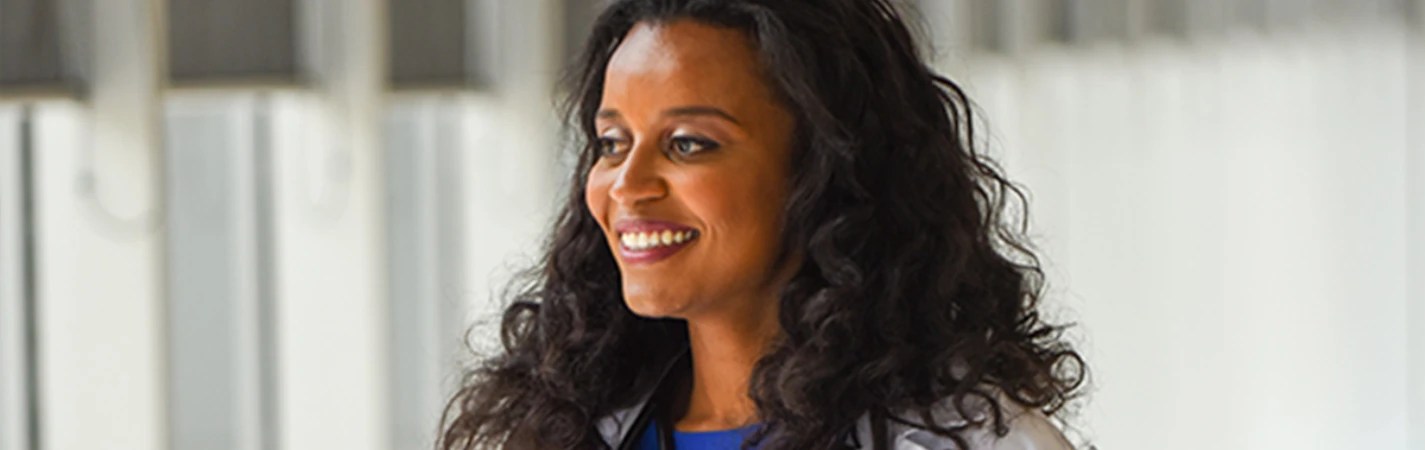 A woman with long curly hair smiling