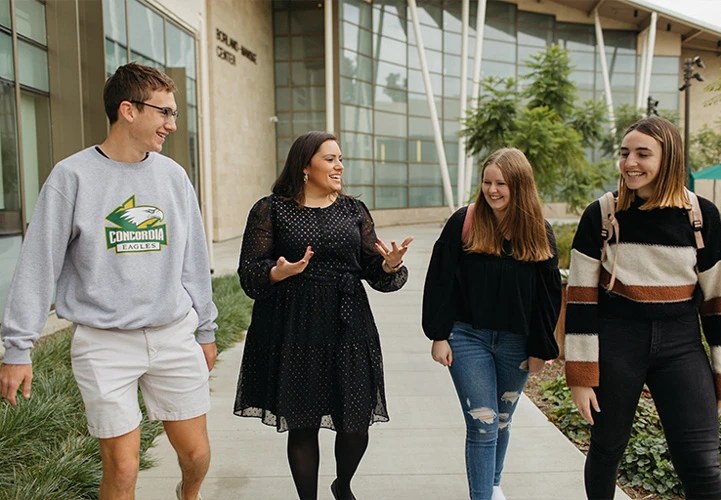 A group of people walking on a sidewalk
