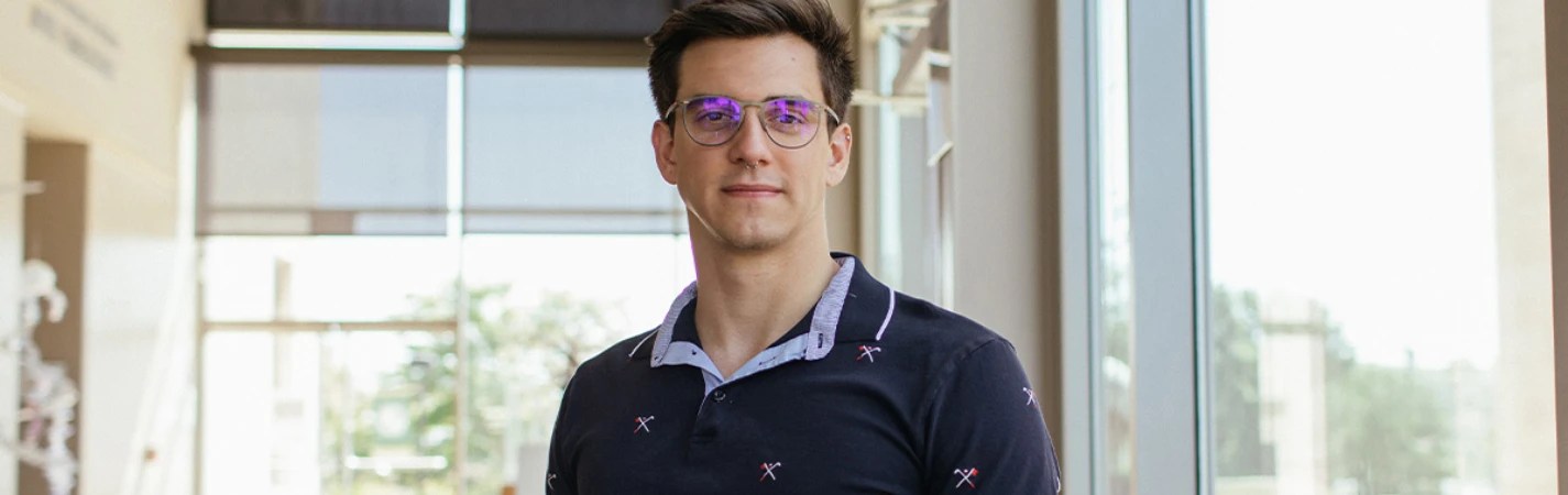 A man wearing glasses and a polo shirt