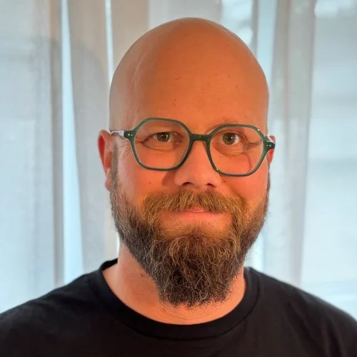 A man with a beard and glasses