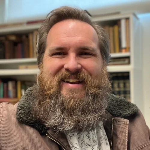 A man with a beard smiling