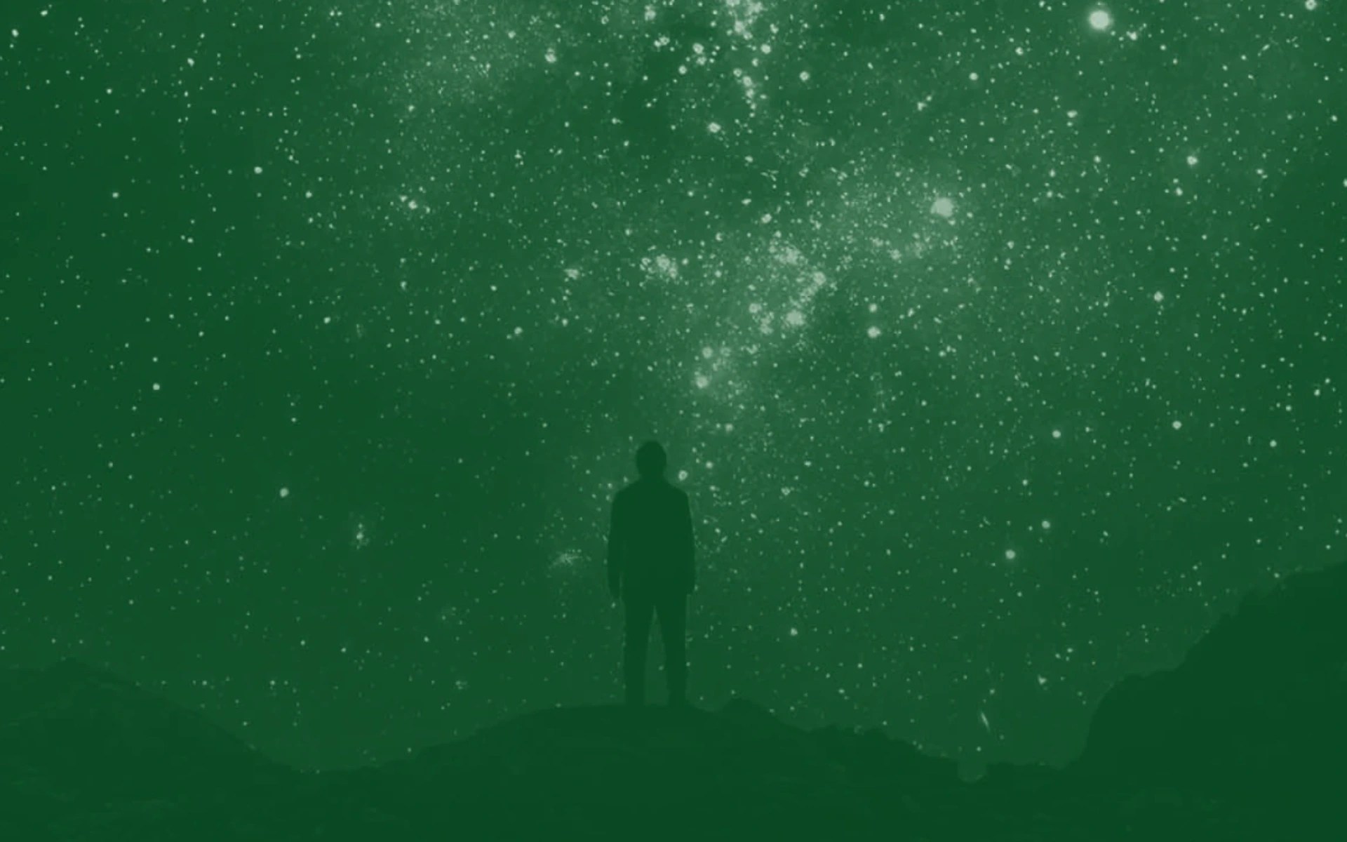 A person standing on a hill with stars in the sky
