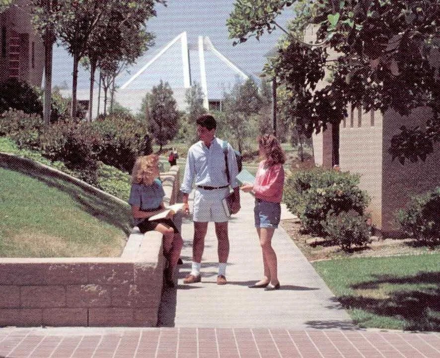 A group of people standing on a sidewalk