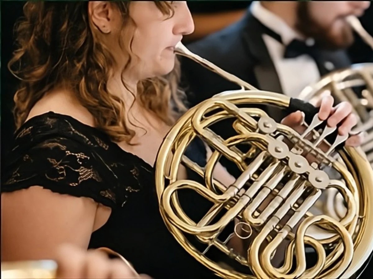 A woman playing a french horn