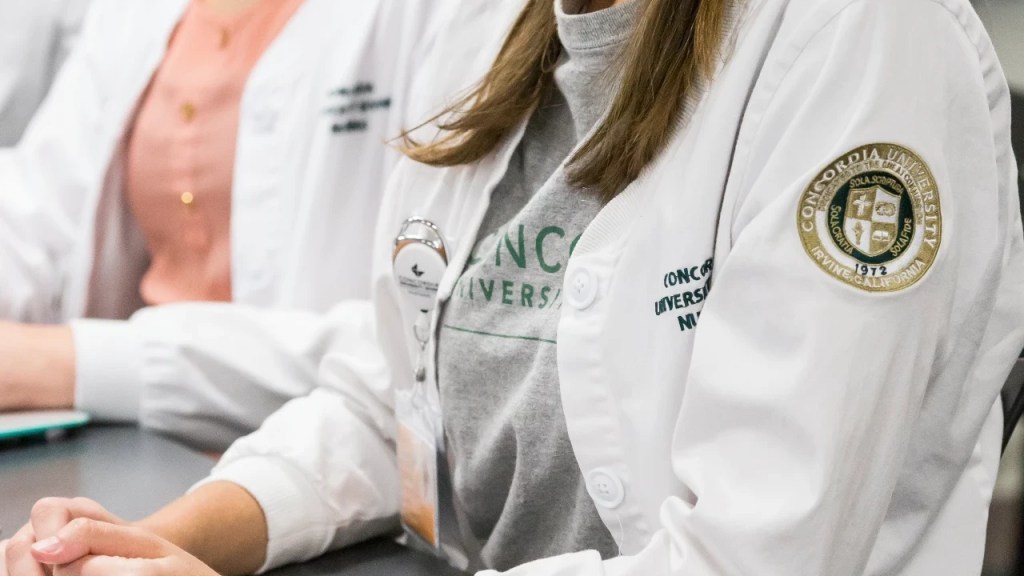 A close-up of a woman wearing a white coat