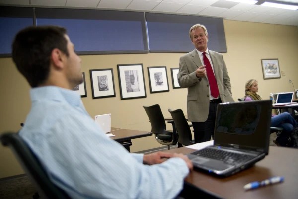 A man standing in front of a laptop